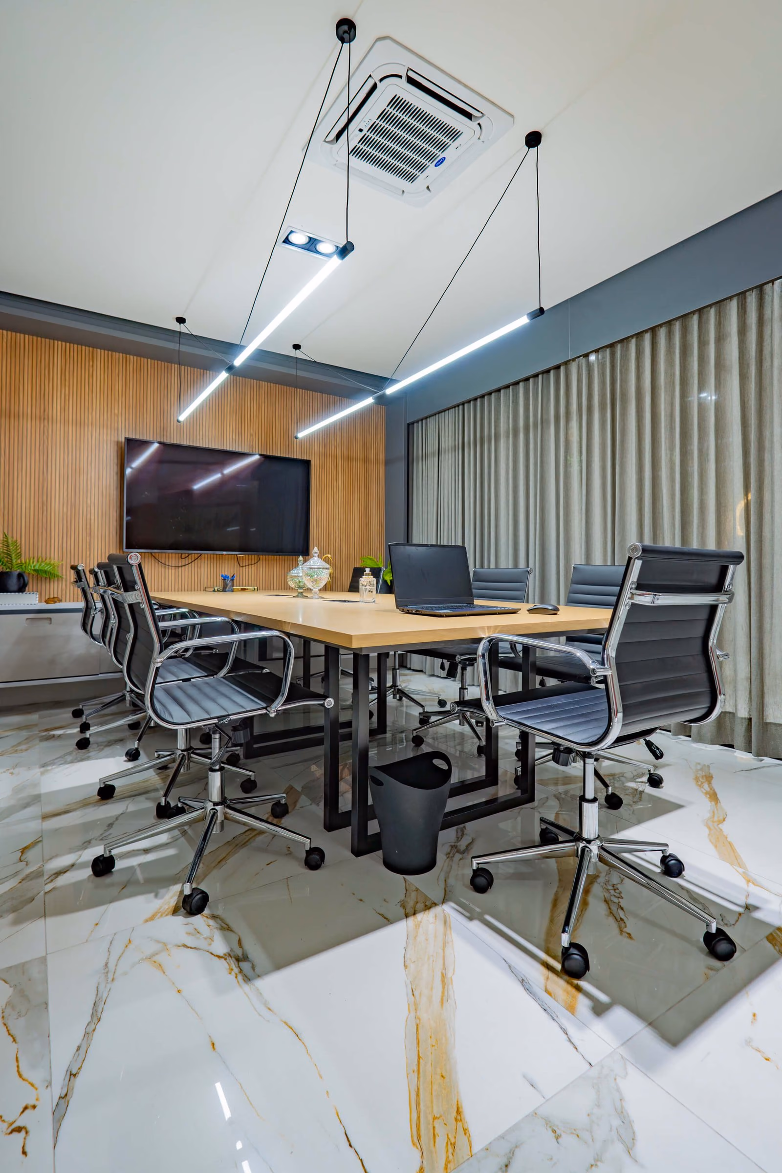 Sala comercial com mesa e painel de madeira planejados