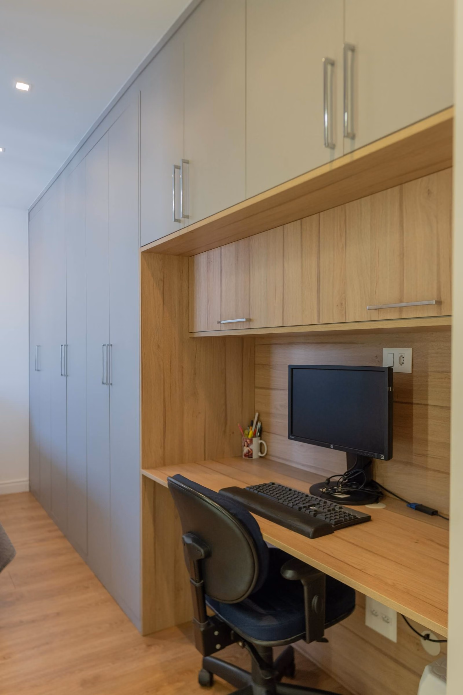 Home office compacto com bancada e armários planejados
